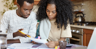 Young couple reviewing student loan debt bills